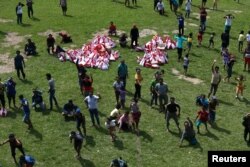 Villagers affected by the earthquake wave after an Indonesian military helicopter dropped aid in Lindu village south of Palu, Central Sulawesi, Indonesia, Oct. 7, 2018.