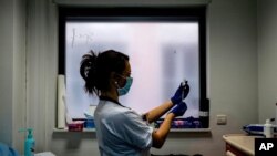 FILE - A nurse prepares a dose of the AstraZeneca COVID-19 vaccine at the Edouard Herriot hospital in Lyon, central France. 