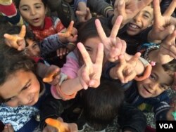 Children all over the region re-captured by the Iraqi Army flash victory signs, saying they have been freed of Islamic State militants. Khazir Camp, Kurdish Iraq on Dec. 1, 2016. (H.Murdock/VOA)