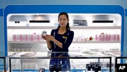 FILE - A North Korean saleswoman holds up a product at a shop in the Pyongyang Cosmetics Factory in Pyongyang, North Korea, Saturday, Sept. 8, 2018. (AP Photo/Kin Cheung)