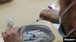 Seorang petugas kesehatan sedang mempersiapkan vaksin COVID-19 buatan Pfizer-BioNTech di Nice, Perancis, 9 April 2021. 