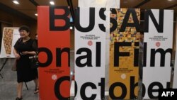 A woman walks past signboards of the Busan International Film Festival (BIFF) after a press conference on the festival overview in Seoul, Sept. 4, 2018. 