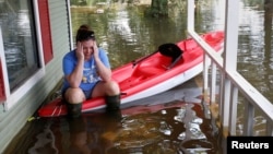 ស្ត្រី​ម្នាក់​អង្គុយ​នៅ​លើ​ទូក​មួយ​ដែល​អណ្តែត​ក្បែរ​ផ្ទះ​មិត្តភក្តិ​របស់​គាត់ បន្ទាប់​ពី​មាន​ព្យុះ Harvey ក្នុង​ក្រុង Orange រដ្ឋ Texas កាលពី​ថ្ងៃទី១ ខែកញ្ញា ឆ្នាំ២០១៧។