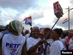 FILE - Supporters of Ghana opposition leader Nana Akufo-Addo wave boxes of Kalyppo juice in Accra, Ghana, Oct. 11, 2016.