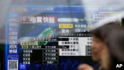 แฟ้ม - ผู้คนเดินผ่านโทรทัศน์ที่ถ่ายทอดรายงานข่าวสดเหตุแผ่นดินไหว ในโอกินาวา และความเสียหายจากแผ่นดินไหวไต้หวัน เมื่อวันที่ 3 เม.ย. 2024 ในกรุงโตเกียว (AP Photo/Eugene Hoshiko)