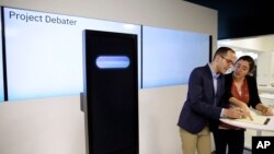 Dan Zafrir, left, and Noa Ovadia, right, prepare for their debate against the IBM Project Debater in San Francisco, June 18, 2018. (AP Photo/Eric Risberg)