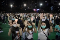 Participants gesture with five fingers, signifying the "Five demands - not one less" during a vigil for the victims of the 1989 Tiananmen Square Massacre at Victoria Park in Causeway Bay, Hong Kong, June 4, 2020.