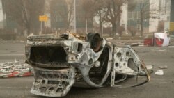 A burned-out automobile is seen on a square near an administrative quarter in central Almaty on Jan. 6, 2022.