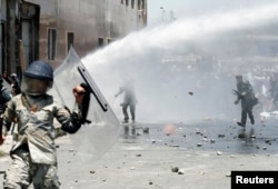 Afghans throw stones toward security forces during a protest in the wake of a deadly bombing Wednesday, in Kabul, Afghanistan, June, 2, 2017.