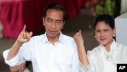 Presiden Joko Widodo dan Ibu Negara Iriana usai melaksanakan hak pilih di TPS 008 Gambir, Jakarta Pusat, Rabu, 17 April 2019. (Foto: AP)