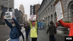 شماری از معترضان در مقابل محکمۀ سانفرانسیسکو مخالفت شان را در مورد ممنوعیت شهروندان هفت کشور نشان می دهند