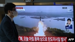 A man walks past a television screen showing a news broadcast with file footage of a North Korean missile test, at a train station in Seoul on October 31, 2024.