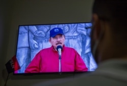 A man watches a televised national address by Nicaraguan President Daniel Ortega, at his home in Managua, June 23, 2021.