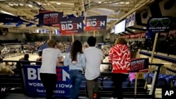 Younger caucusgoers hold signs for Democratic presidential candidate Joe Biden at the Knapp Center on the Drake University campus in Des Moines, Iowa, Feb. 3, 2020.