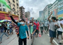 Para pengunjuk rasa berbaris selama protes flash mob di kotapraja Mingalar Taung Nyunt di Yangon, Myanmar, Minggu, 11 Juli 2021. (AP Photo)