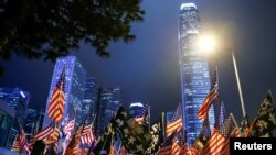 FILE - Protesters hold U.S. flags during a gathering at Edinburgh Place in Hong Kong, China, Nov. 28, 2019. 