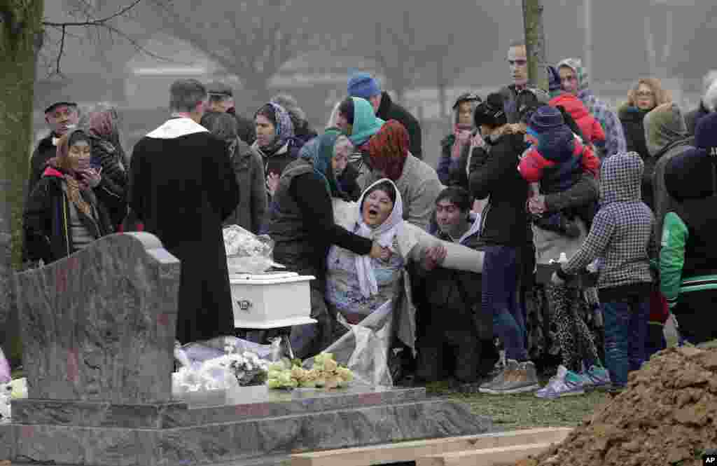 The mother of Maria Francesca, who died of sudden infant death syndrome, cries in front of the coffin of her baby during the funeral in Wissous, outside Paris, France. Wissous offered a gravesite for the baby after the mayor of Champlan, where the child and mother lived, reportedly refused a burial plot.