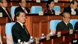 Cambodian Prime Minister Hun Sen, left, sits inside the session hall of the National Assembly with lawmakers from his Cambodian People's Party, in Phnom Penh, Cambodia, Sept. 24, 2013.
