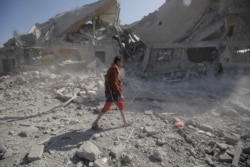 FILE - A Yemeni man walks amid the rubble of a Houthi-held detention center destroyed by Saudi-led airstrikes in Dhamar, Yemen, Sept. 1, 2019.