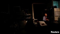 A waiter walks at the kitchen of a restaurant, during a massive blackout in Caracas, Venezuela, Dec. 18, 2017.