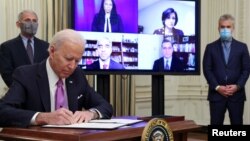 Presiden AS Joe Biden menandatangani perintah eksekutif terkait penanganan COVID-19 didampingi Dr. Anthony Fauci dan Jeff Zients listen di Gedung Putih (foto: dok0. 
