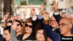 People sing the Maltese national anthem as they show a peace sign while attending a funeral ceremony of journalist Daphne Caruana Galizia, who was murdered in a car bomb attack, at the Rotunda Parish Church in Mosta, Malta, Nov. 3, 2017. 