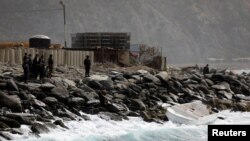 Anggota pasukan khusus memperhatikan kapal yang kosong di lepas pantai setelah pemerintah Venezuela mengumumkan tentang serangan tentara bayaran, di Macuto, Venezuela, 3 Mei 2020.