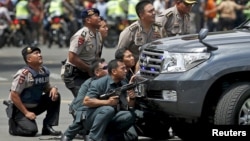 Police officers react near the site of a blast in Jakarta, Indonesia, January 14, 2016. Several explosions went off and gunfire broke out in the center of the Indonesian capital on Thursday and police said they suspected suicide bombers were responsible. Reuters/Darren Whiteside