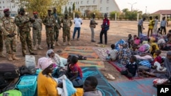 Des responsables des Forces de défense du peuple du Sud-Soudan rendent visite à des habitants réfugiés au quartier général de l'armée après une nuit de violence à Juba, au Sud-Soudan, le 17 janvier 2025.