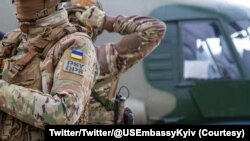 Des parachutistes ukrainiens et américains se préparent pour une prochaine opération aéroportée conjointe.