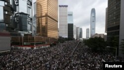 资料照片: 抗议者在香港街头大游行，反对拟议中允许将香港犯罪嫌疑人引渡至中国大陆的条例。(2019年6月12日)