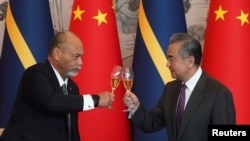 中国外交部长王毅2024年1月24日在北京同瑙鲁外长莱昂纳尔·安格明(Lionel Aingimea)举行会谈并签署恢复外交关系的联合公报后碰杯庆贺。（媒体联访照片）