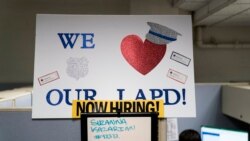 In this Sept. 9, 2020, photo a "Now Hiring" sign is placed on a wall in the office of the Los Angeles Police recruitment and employment division in Los Angeles. (AP Photo/Jae C. Hong)