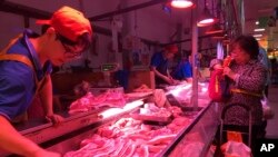 资料照：一名北京市民在一家肉铺购买猪肉。（2019年9月11日）