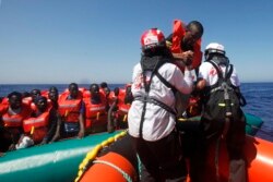 Migran Afrika yang terombang-ambing di atas perahu karet di Laut Mediterania, lepas Libya, diselamatkan oleh kapal MV Geo Barents MSF (Doctors Without Borders), di rute Mediterania tengah, Senin, 20 September 2021. (AP Photo/Ahmed Hatem)