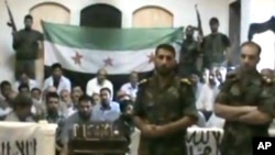 This image made from a video released by the Baraa Brigades and accessed Sunday, Aug. 5, 2012, purports to show Free Syrian Army soldiers guarding a group of Iranians abducted a day earlier.