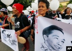 FILE - Supporters of the late Philippine dictator Ferdinand Marcos display his images prior to marching towards the Supreme Court for an overnight vigil, Nov. 7, 2016.