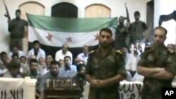 This image made from a video released by the Baraa Brigades and accessed Sunday, Aug. 5, 2012, purports to show Free Syrian Army soldiers guarding a group of Iranians abducted a day earlier.