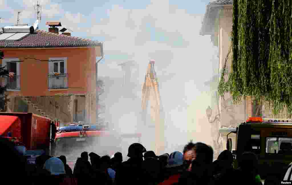 Dust is seen coming out from falling rubble following an aftershock in Amatrice, central Italy, Aug. 25, 2016.