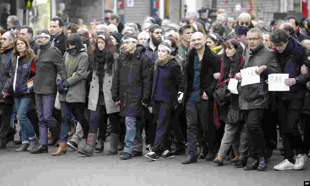 Charlie Hebdo newspaper staff march with relatives of Jewish victim of the koscher supermarket, Michel Saada, in Paris, France, Jan. 11, 2015.