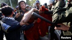 ព្រះសង្ឃ​មួយ​អង្គ​ការពារ​ព្រះកាយ​ពី​ការ​វាយ​របស់​ក្រុម​ប៉ូលិស​ក្នុង​អំឡុង​បាតុកម្ម​នៅ​មុខ​សាលា​រាជធានី​ភ្នំពេញ​ កាល​ពី​ថ្ងៃ​អង្គារ​ទី២៤ ខែធ្នូ​នេះ។ អតីត​អ្នក​ភូមិ​បឹងកក់​ប្រមាណ​១០០​នាក់ ដោយ​រួម​មាន​ព្រះសង្ឃ​ផង​ បាន​ធ្វើ​ការ​តវ៉ា​បិទ​ផ្លូវ​ព្រះមុនីវង្ស​ដើម្បី​ទាមទារ​ឲ្យ​រដ្ឋាភិបាល​ផ្តល់​សំណង​ថែម​ទៀត​ចំពោះ​ការ​បណ្តេញ​ប្រជាពលរដ្ឋ​ដោយ​បង្ខំ​ចេញ​ពី​សហគមន៍​បឹងកក់។