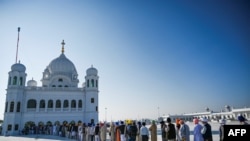 អ្នក​ហែ​ក្បួន​ធម្មយាត្រា​ដែល​មាន​ជំនឿ​លើ​ព្រះ​គ្រូ Sikh តម្រង់​ជួរ​នៅ​ទីសក្ការៈ​បូរជា Baba Guru Nanak Dev នៅ​ព្រះវិហារ Gurdwara Darbar Sahib ក្នុង​ទីក្រុង Kartarpur ជិត​ព្រំ​ដែន​ឥណ្ឌា កាល​ពី​ថ្ងៃ​ទី​៩ វិច្ឆិកា ២០១៩។