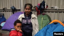 Tsega, 38 ans, qui a fui l'Érythrée il ya six ans, pose avec son fils Naher, 5 ans, devant leur tente dans un refuge pour migrants à Calais, en France, le 28 octobre 2014.