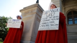 April Houston and Lara Martin hold signs while dressed as Handmaids in protest of Georgia's anti-abortion "heartbeat" bill at the Georgia State Capitol in Atlanta, Georgia, U.S., May 7, 2019.