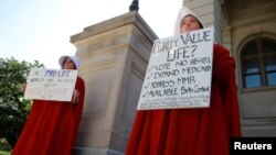April Houston and Lara Martin hold signs while dressed as Handmaids in protest of Georgia's anti-abortion "heartbeat" bill at the Georgia State Capitol in Atlanta, Georgia, U.S., May 7, 2019. 