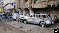 Petugas keamanan meninggalkan lokasi serangan bom di wilayah Karrada, Baghdad, Irak (20/11).