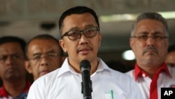 FILE - Indonesian Youth and Sports Minister Imam Nahrawi, center, speaks to the media during a press conference in Jakarta, Indonesia, Sept. 19, 2019.