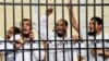 Supporters of the Muslim Brotherhood and other Islamists call out from the defendants cage as they receive sentences ranging from death by hanging for one, life in prison for 13 and 8-15 years for the others after they were convicted of murder, rioting, and violence in a mass trial in Alexandria, Egypt, May 19, 2014.