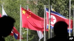 ទង់ជាតិចិន​បក់រវិចជាមួយនិង​ទង់ជាតិប្រជាជាតិ​ដទៃទៀតដែលចូលរួម​ក្នុង​កិច្ចប្រជុំរដ្ឋមន្ត្រីអាស៊ាន​ដែលបាន​និងកំពុងរៀបចំឡើង​នៅនុសា ឌុសា បាលី ឥណ្ឌូនេស៊ី កាល​ពីថ្ងទី២០ កក្កដា ២០១១។