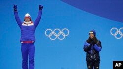 Women's cross-country 7.5/7.5km skiathlon gold medalist Charlotte Kalla, of Sweden, right, applauds as silver medalist Marit Bjoergen, of Norway, reacts during their medals ceremony at the 2018 Winter Olympics in Pyeongchang, South Korea, Feb. 10, 2018.